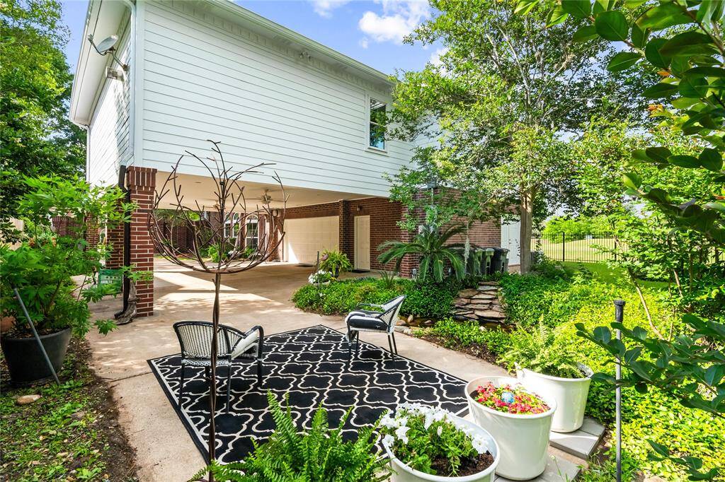 THIS TRANQUIL GARDEN SPACE FEATURES LUSH LANDSCAPING, A DECORATIVE FOUNTAIN, AND A CHARMING PATIO PERFECT FOR MORNING COFFEE OR EVENING WINE.