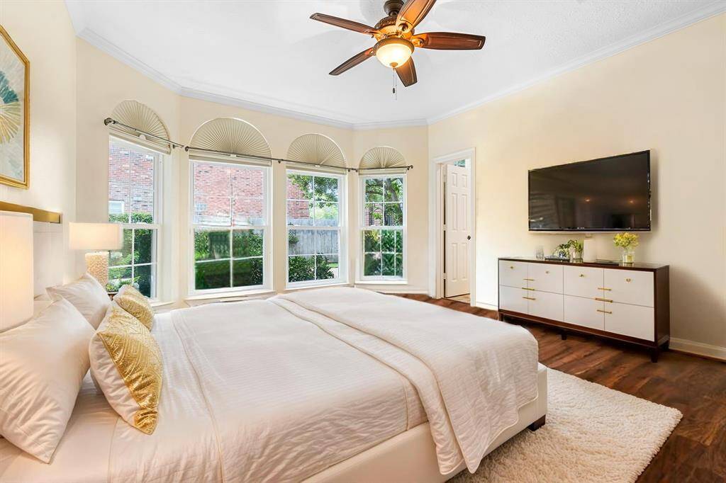 BEDROOM 2 FEATURES A CEILING FAN, RICH WOOD FLOORING, CROWN MOLDING, AND A MODERN LAYOUT. **This room has been virtually staged.