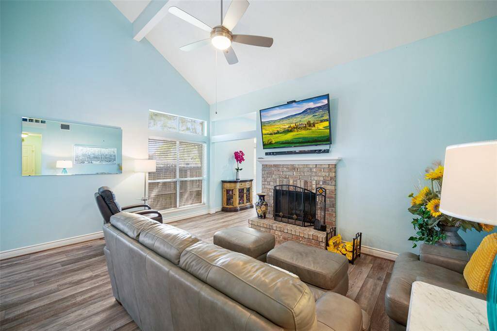 The den features a rustic brick fireplace, perfect for cozy evenings.