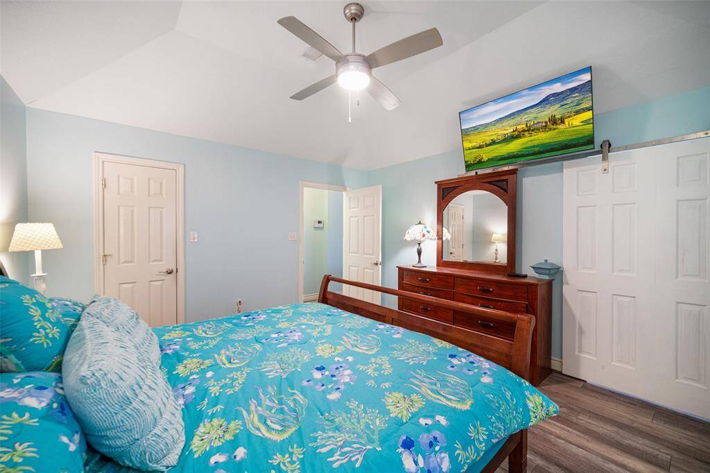 barn doors in the primary bedroom add a touch of warmth and charm, enhancing the room’s cozy and inviting ambiance.