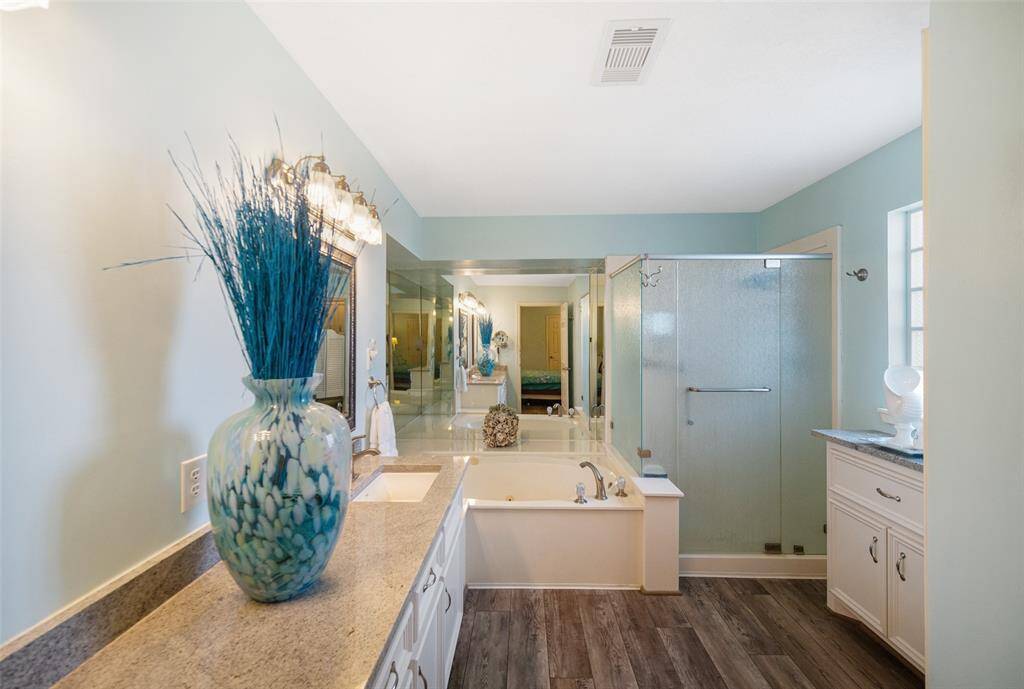 The primary ensuite features double sinks, cabinets for your essentials, a relaxing soaking tub, and a glass shower.
