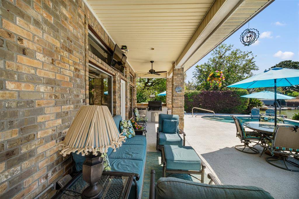 The covered patio is equipped with ceiling fans, an outdoor refrigerator, and a built-in grill.
