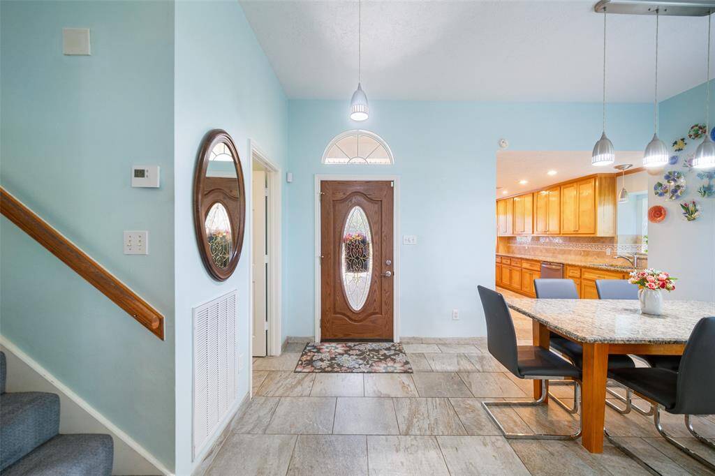 A beautifully designed wood front door with etched glass warmly welcomes you into this home. Tile flooring flows throughout the entry and into the breakfast room.