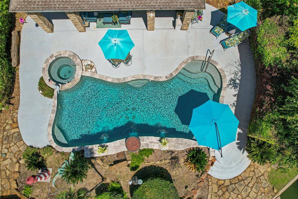 This aerial view of the sparkling pool and hot tub showcases the ultimate backyard retreat.
