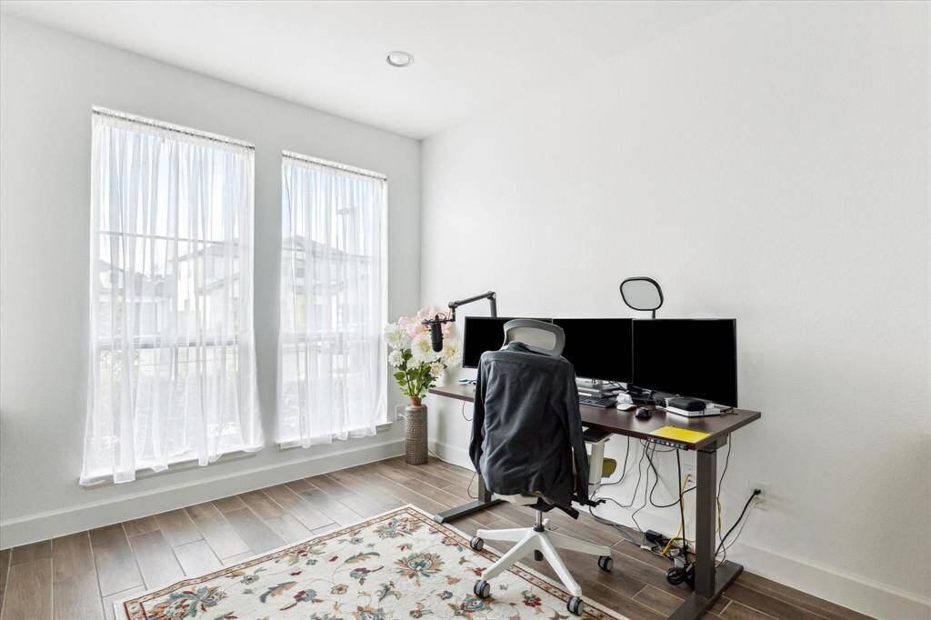 The home office features beautiful floors and large windows.