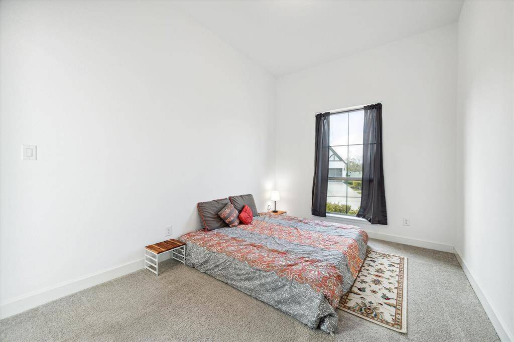 Secondary bedroom features awindow and plush carpet.