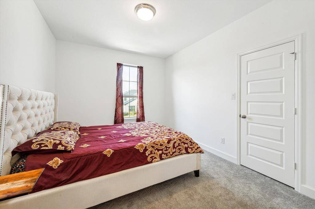 Third bedroom features awindow and plush carpet.