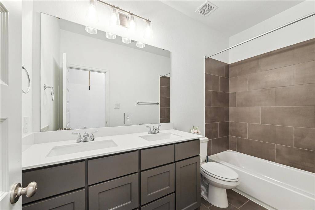 Fourth bathroom features atub/shower combo and long vanitywith dual sinks.