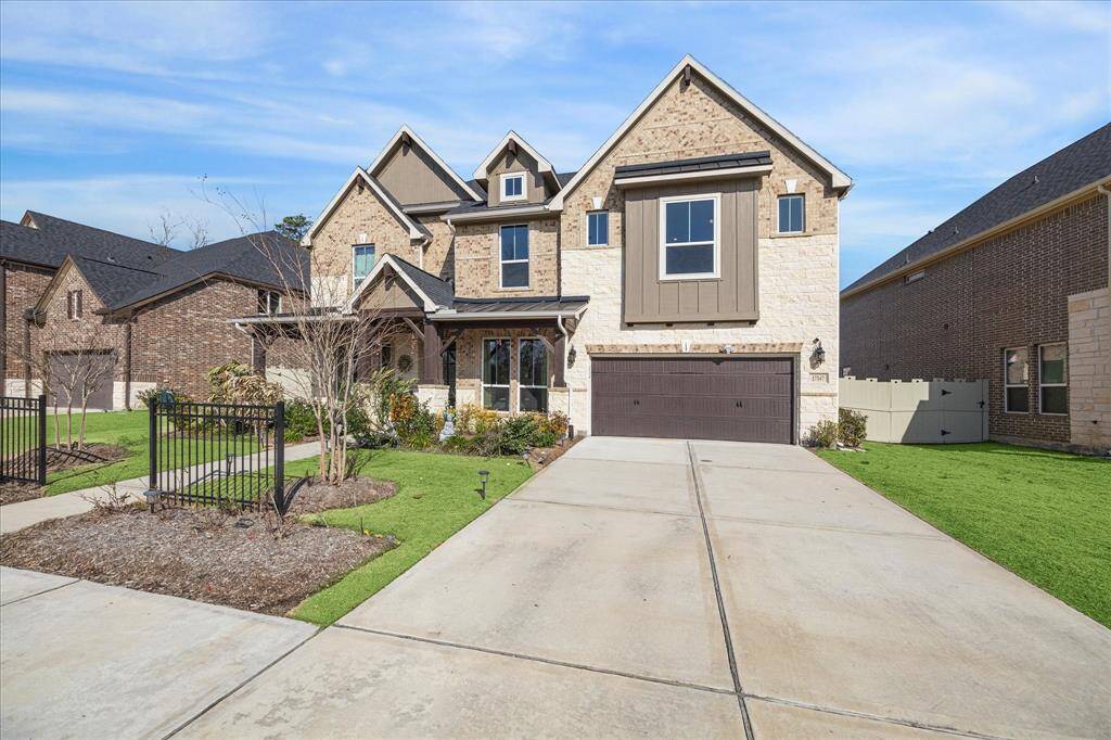 a stunning two-story home front view with a two-car garage, and a covered front porch. The well-maintained landscaping, extended driveway, and fenced backyard enhance the home's curb appeal and provide a welcoming atmosphere.