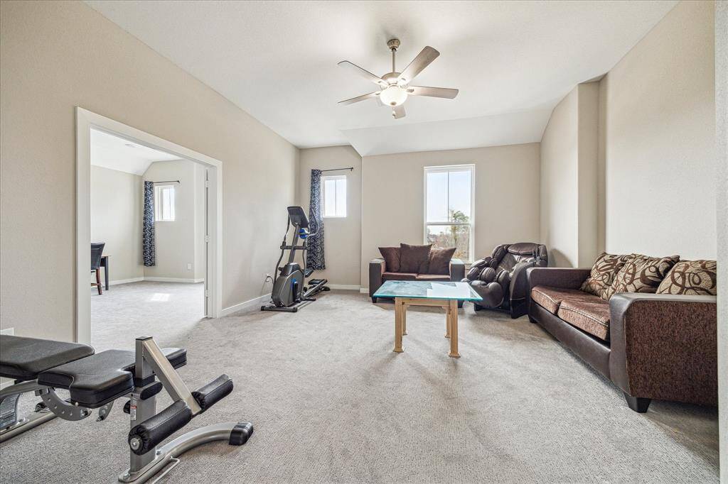 The game room offers a versatile space with ample natural light, neutral-toned walls, and plush carpeting for comfort. Its open layout provides flexibility for entertainment, fitness, or relaxation, making it a functional addition to the home.