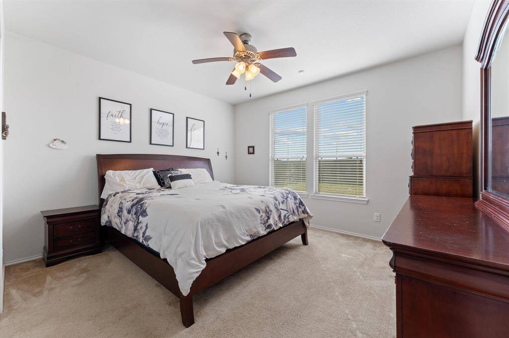 Primary large bedroom, with enough room for a king sized bed, nightstands and a dresser. The room is brightened by natural light from two windows.
