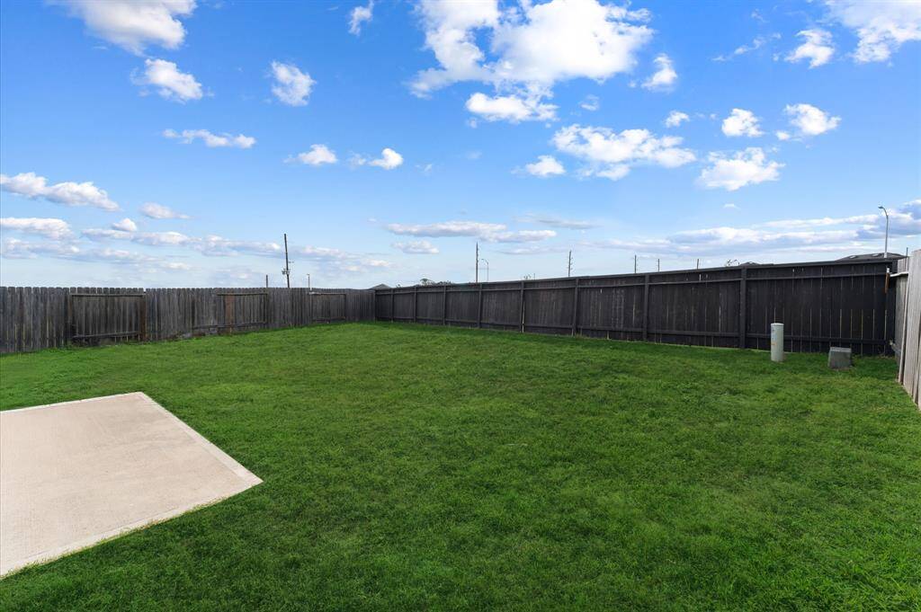View of backyard with small concrete patio. Grass has been digitally enhanced to show potential.