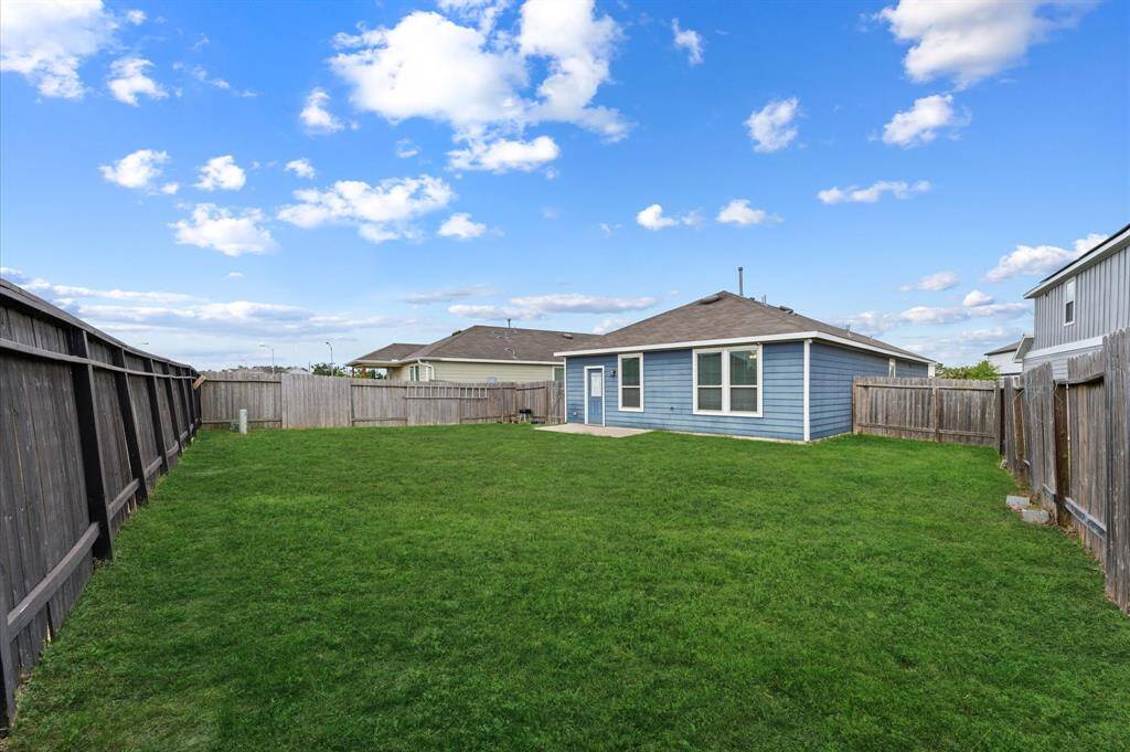 Extra large ,spacious backyard, enclosed by a wooden fence. Ideal for outdoor activities and relaxation.