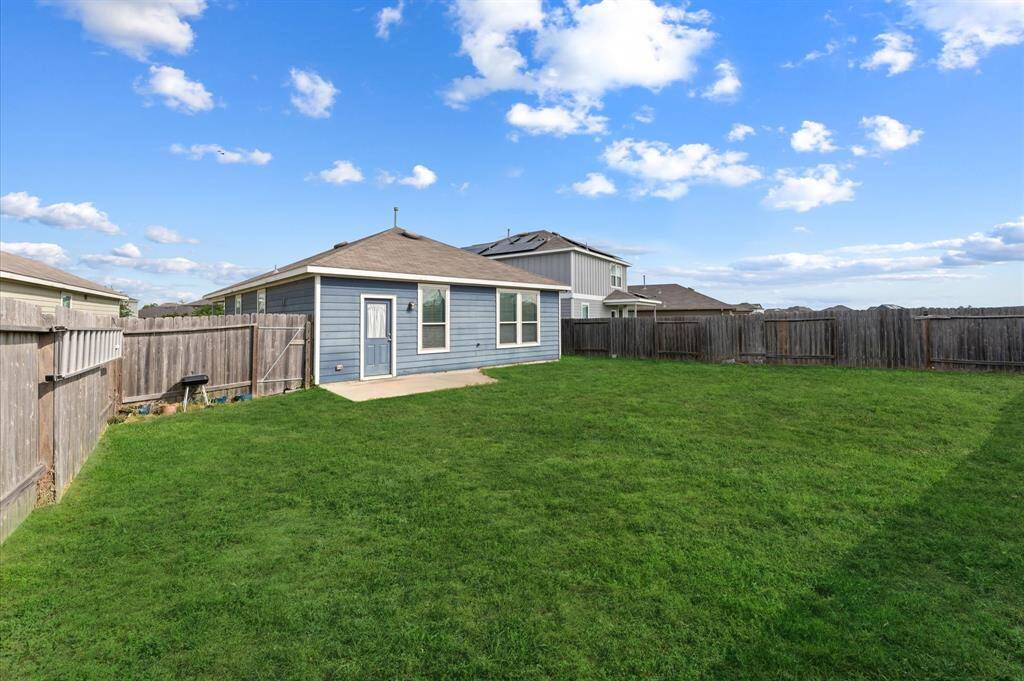 Another photo of the spacious backyard with a small concrete patio, ideal for outdoor activities.Grass has been digitally enhanced to show potential!