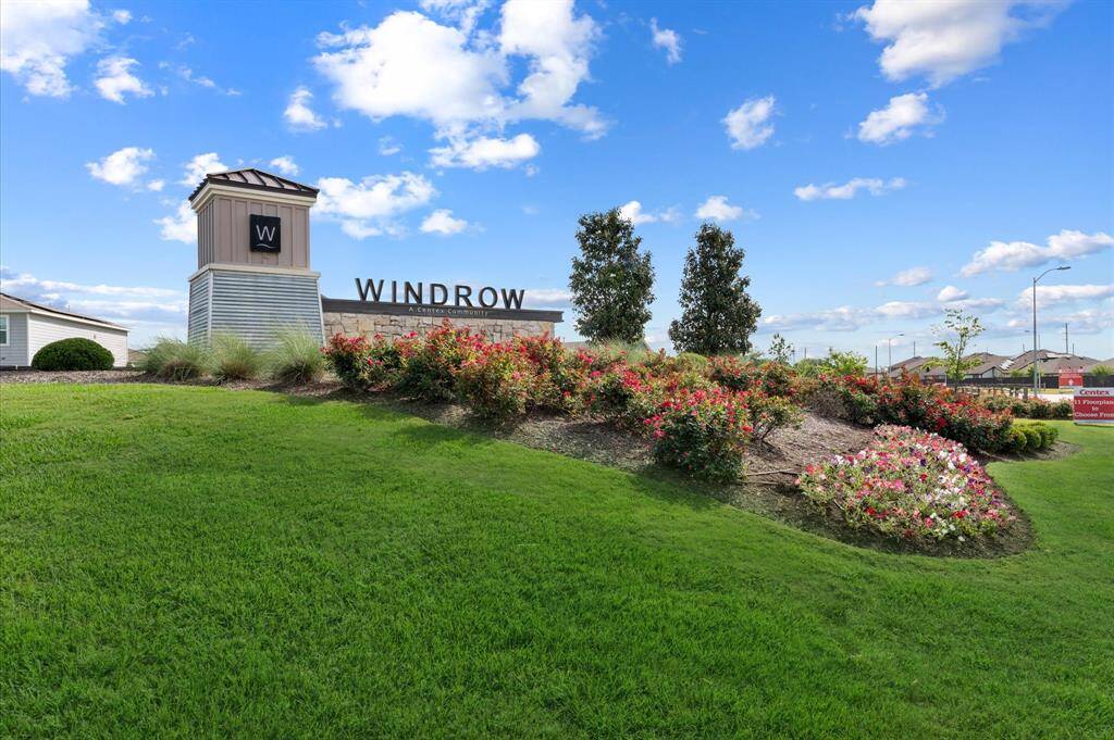 Entrance to Windrow, a serene community with lush green landscaping and vibrant flowerbeds.