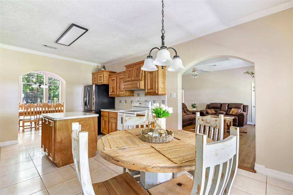 This beautifully bright kitchen features neutral tones that create a clean, timeless look. Sunlight pours in through large windows in both the formal dining room and the eat-in dining area, filling the space with warmth and natural light.