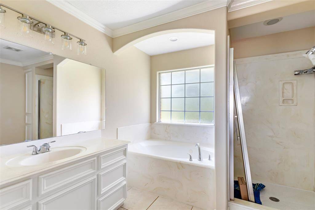 The ensuite bath includes a dual-sink vanity, soaking tub, and a separate shower — your private spa retreat at home.