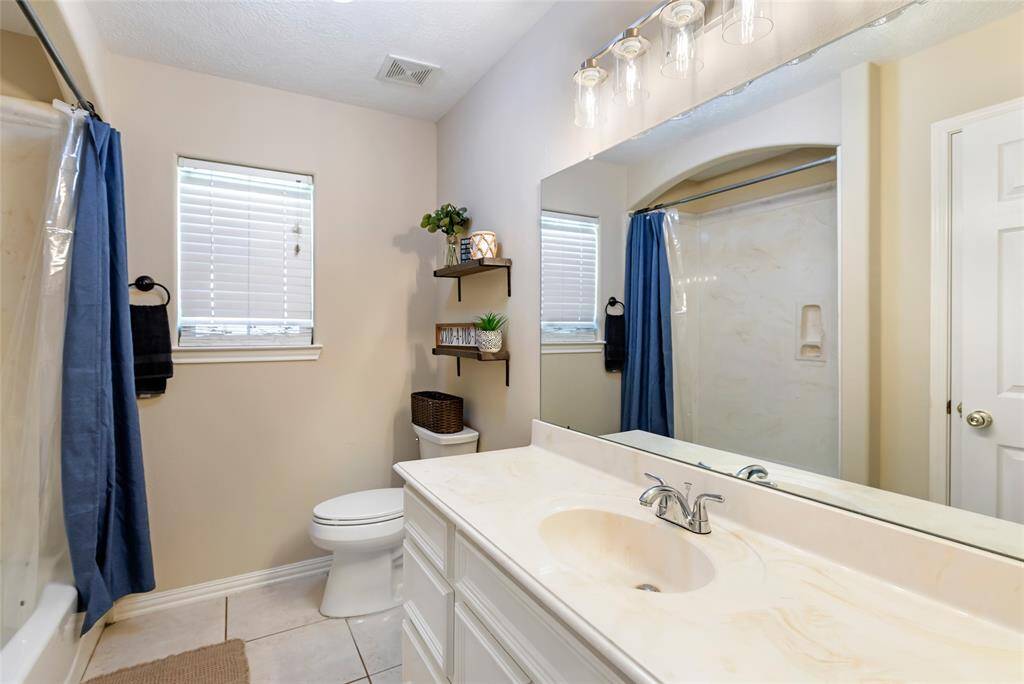 This well-appointed secondary bathroom offers both style and functionality. Featuring a sleek vanity, a bathtub with a shower, and plenty of storage, it’s designed for convenience and comfort.