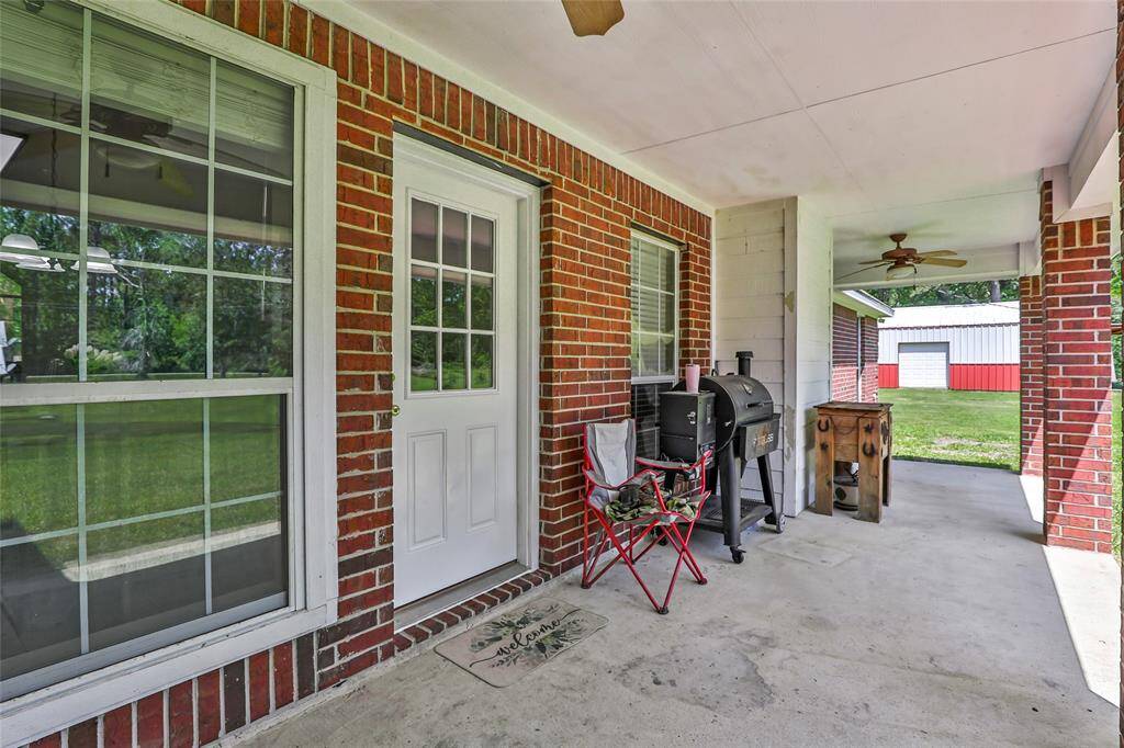 Enjoy outdoor living year-round with this charming covered back patio. Whether you're hosting a barbecue or unwinding with a book, the roofed design provides shade and comfort while you take in the views of your backyard.