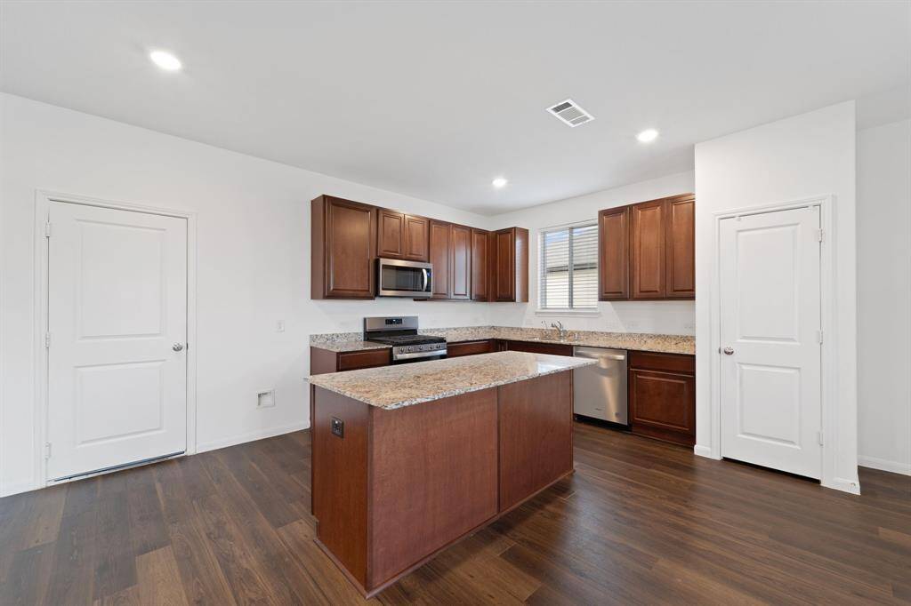 The kitchen is very roomy, and features a functional island for preparing food and a granite countertop throughout.
