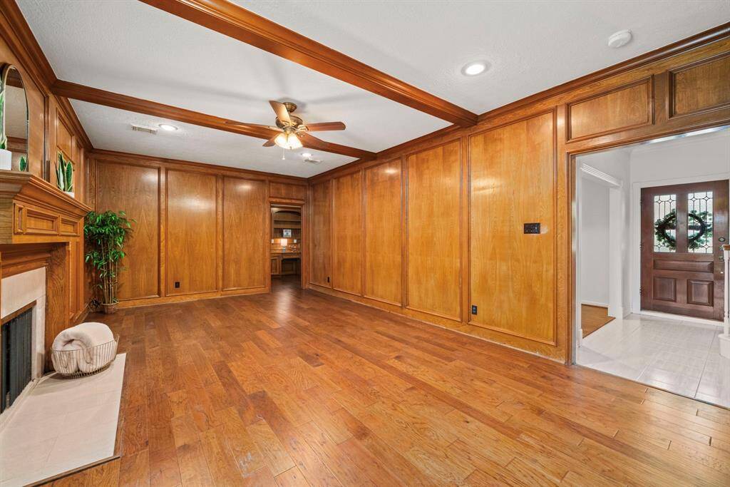 This angle of the inviting family room showcases the ceiling fan & recessed lighting which adds comfort and brightness. There's a view into the front entry and the private study/home office can be seen in he back right corner.