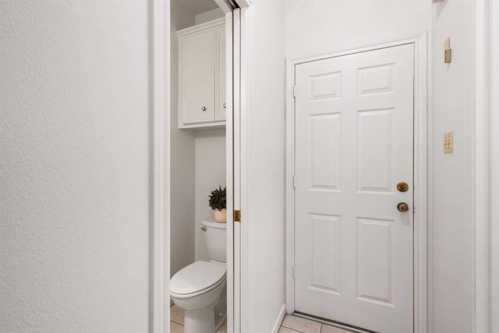 The downstairs 1/2 bath is conveniently located just off the kitchen/breakfast room area and just across from the family room.  The door on the right is to the garage.