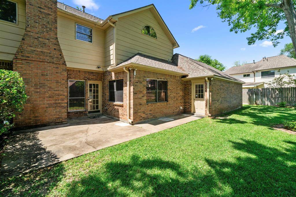 The large patio area is ideal for outdoor gatherings, and the lush lawn provides a serene setting. Perfect for enjoying sunny days in a private, fenced area.