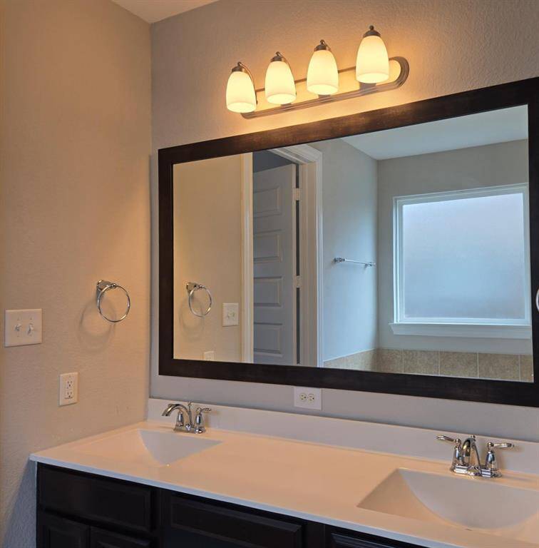 Main suite bathroom. Double sinks, sleek countertops, beautiful framed large mirror and trendy fixtures!