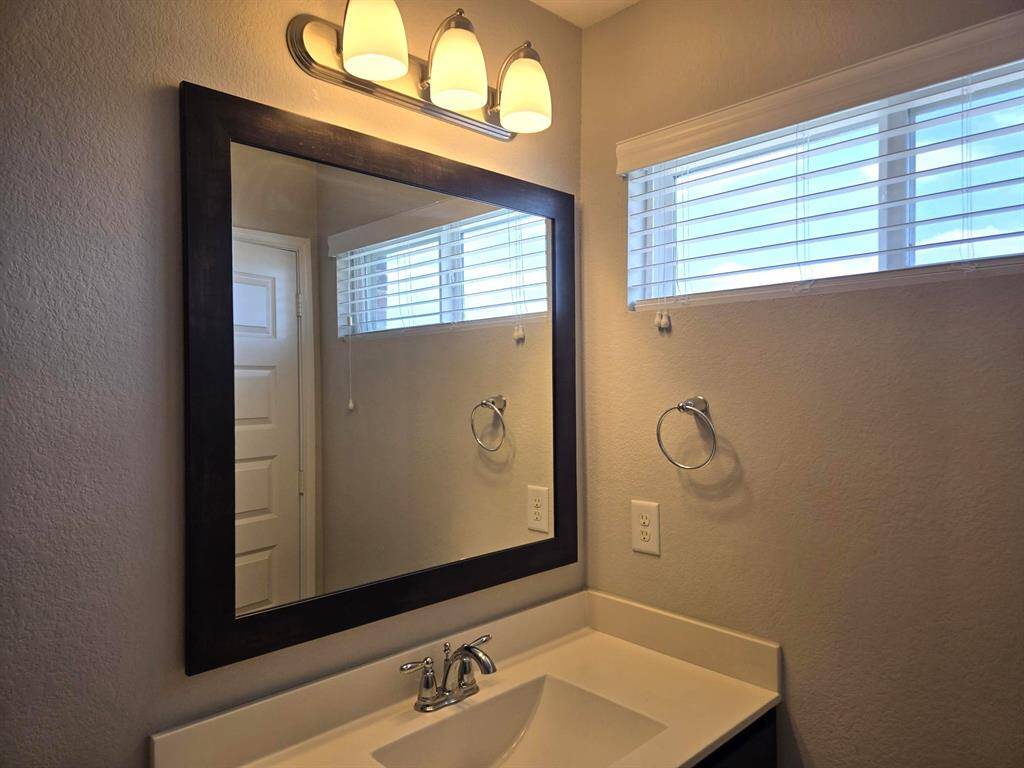 Ensuite bathroom upstairs. Sleek countertop, nice window for added natural light, framed mirror and trendy fixtures!