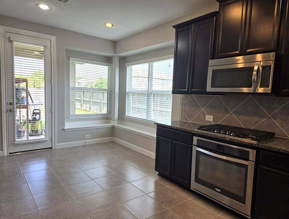 A view of the spacious breakfast room from the kitchen.  Two window seats! Lots of natural light!