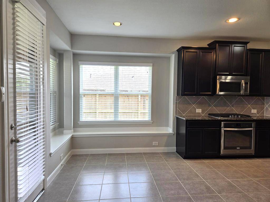 One more view of the breakfast room and on left door to access covered patio and backyard. Nice tile!