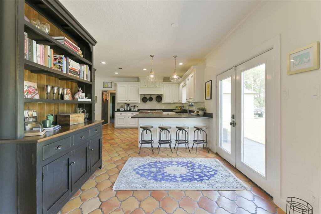 Breakfast area open to kitchen, dining and living room with large access doors to back patio and Guest House.  Fabulous new double doors being installed and note the gorgeous built in with shelves and cabinets for more storage.