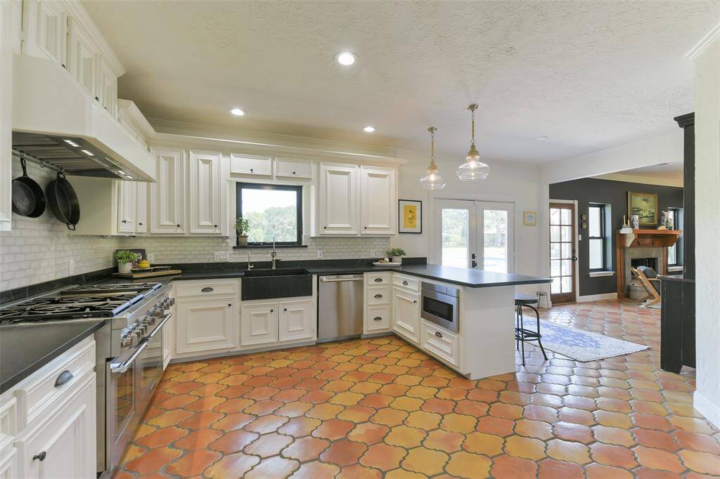 Must see how gorgeous the Saltillo tile looks mixed with the white cabinets, black matte hardware and soapstone counters--note the baby subway tile backsplash throughout.