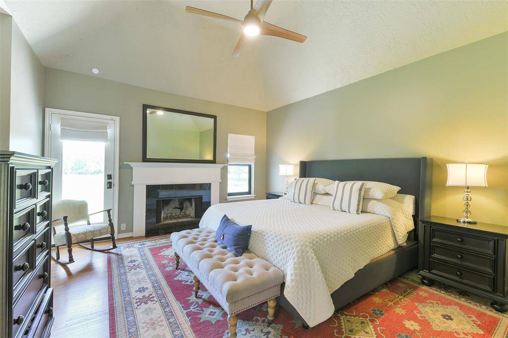 Primary bedroom located on the second floor with charming fireplace, high ceilings, and plenty of natural sunlight.