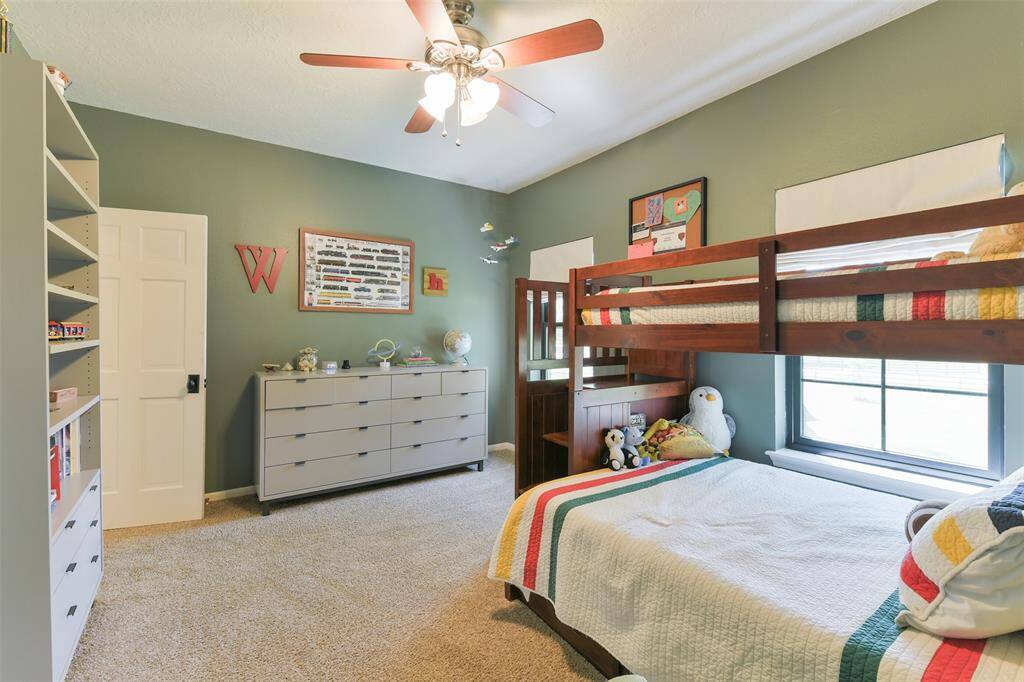 3rd bedroom upstairs with walk in closet and ceiling fan.