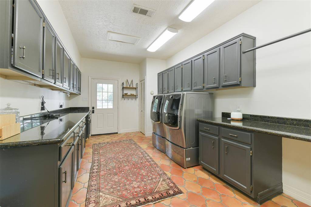 Massive Utility room with access to garage includes plenty of counter space, storage and washer/dryer with pedestals convey.