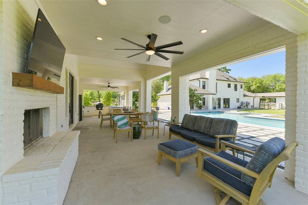 Newly constructed Guest House features a large living area with floor to ceiling white brick fireplace with solid wood beam mantel.  Note the extra large outdoor ceiling fan which provides a cool breeze to enjoy your backyard.