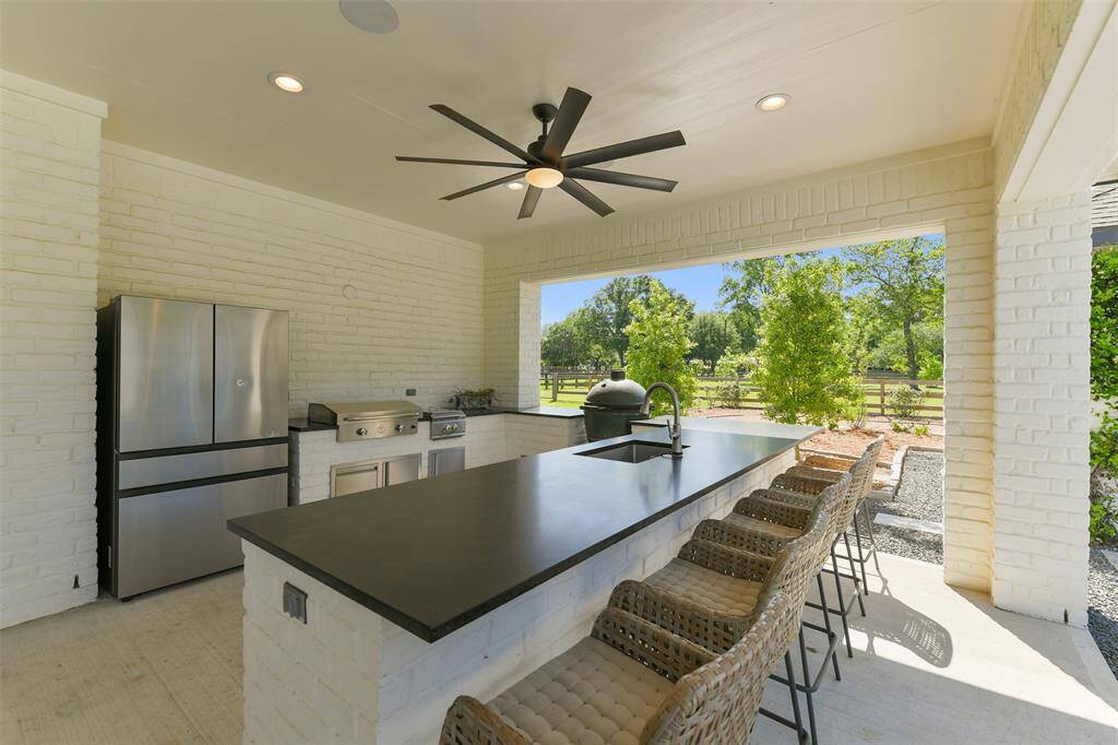 Summer Kitchen is fully equipped including grill, double stove top, full size fridge and leathered granite countertops with undermount sink (Green Egg Excluded, 4 barstools convey).