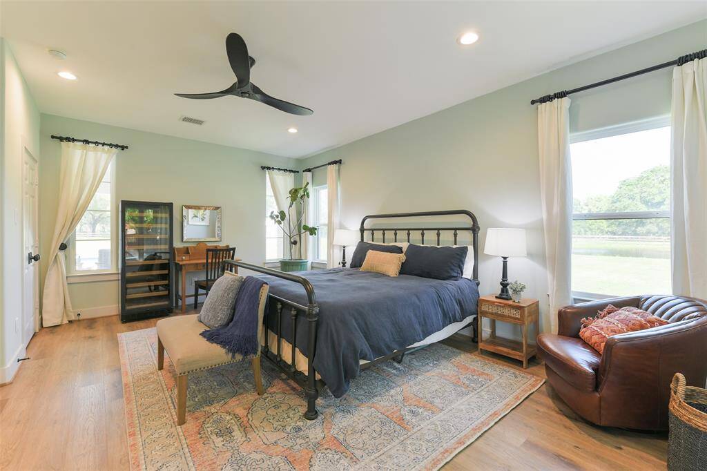 1st bedroom in the Pool House has four large windows and a beautiful black ceiling fan.
