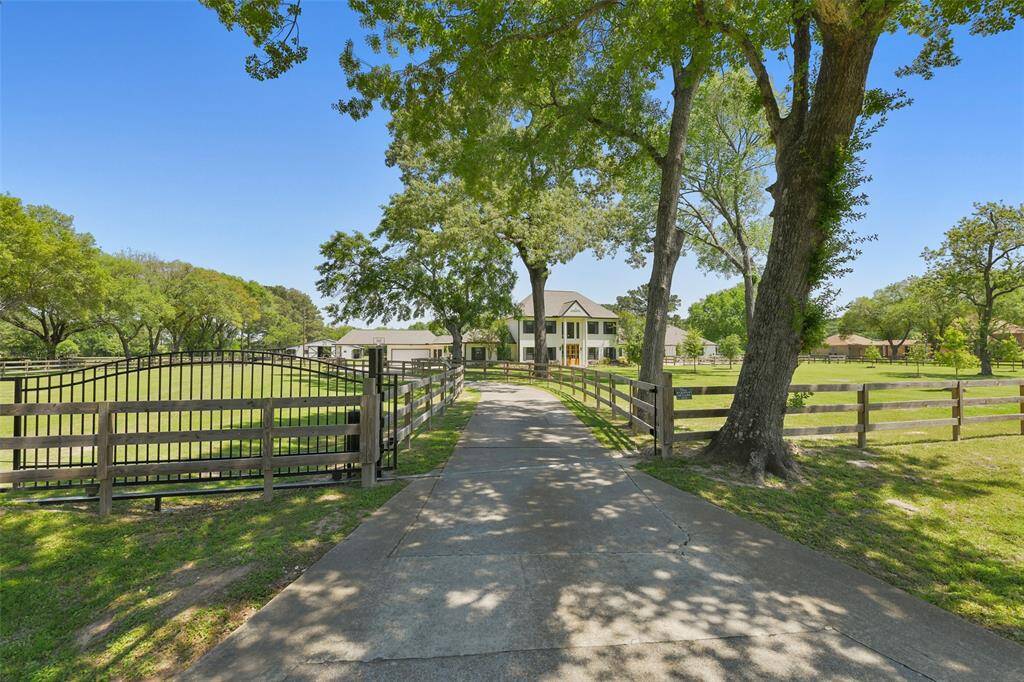 Serene private gated driveway with large mature trees welcomes your guests to your Texas style ranchette.