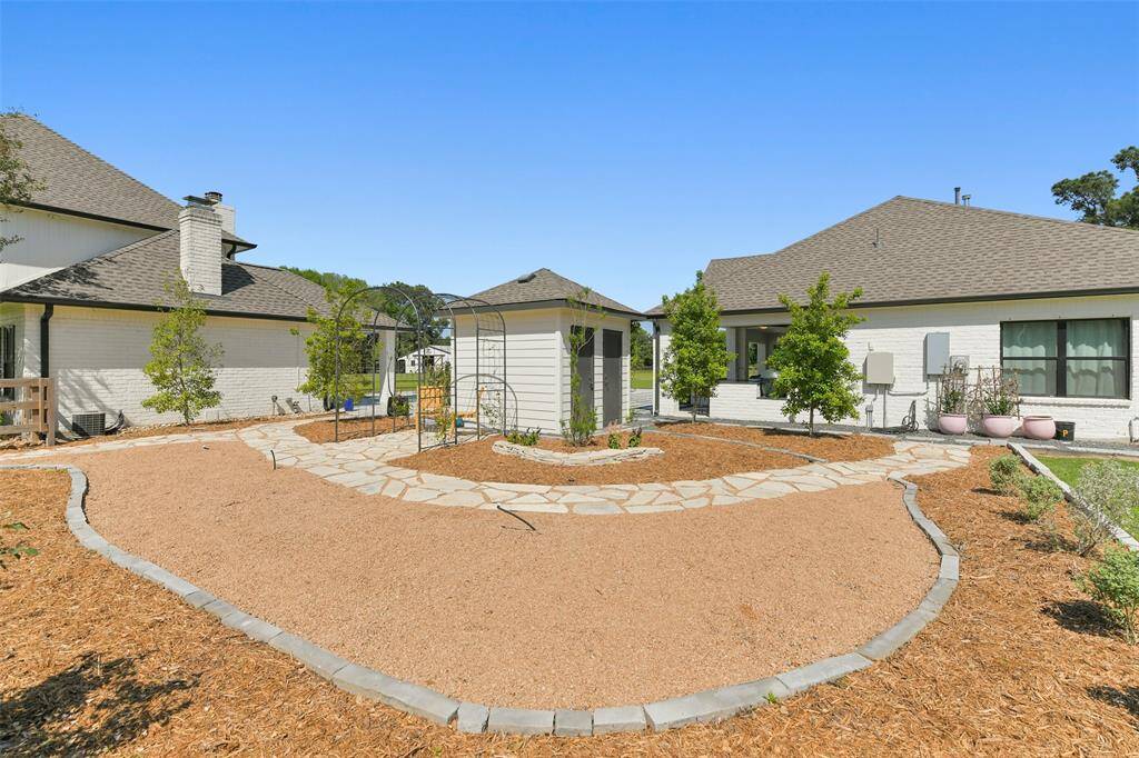 Recently created Walk-Thru Garden has irrigation system and includes rose bushes, Jasmine, Holly Trees, Texas Sage and 2 wrought iron garden arbors with stone walkway which provides a quaint sitting area.