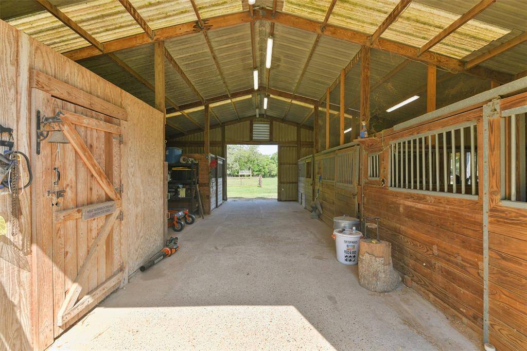 Barn includes 3 stalls on the right, one stall in back left, with tack room on the left.