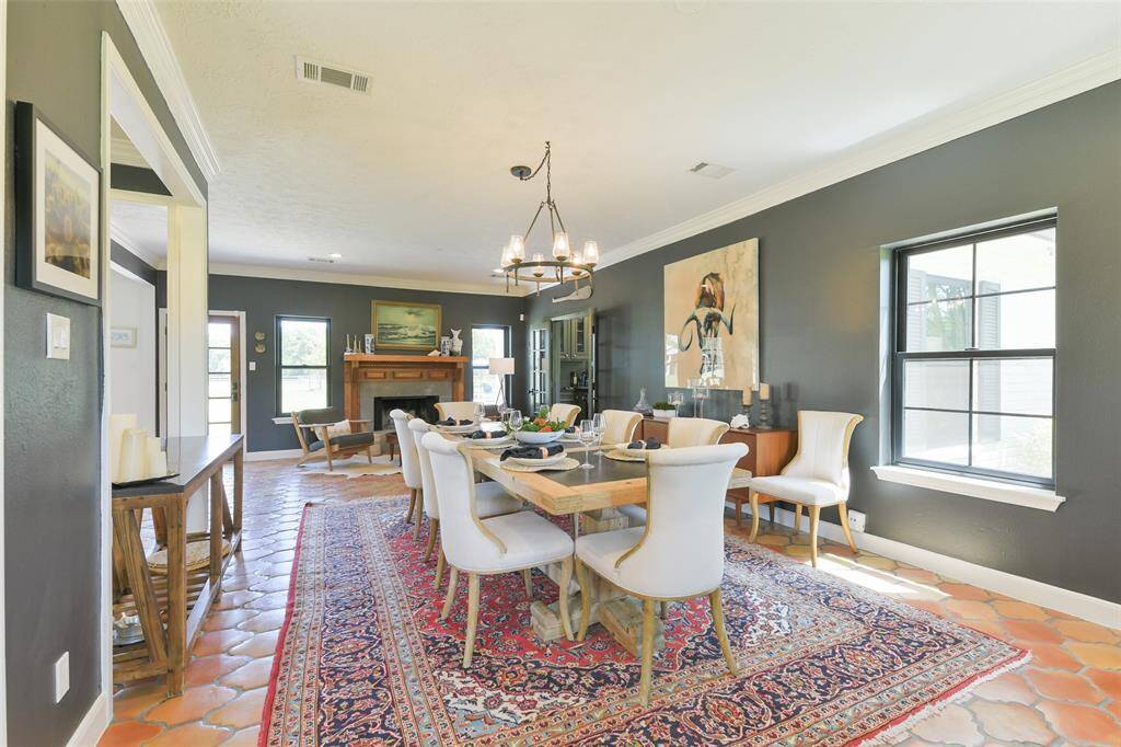 Large dining room with gorgeous new chandelier, lots of windows that provide natural light and a beautiful fireplace to warm up the room.