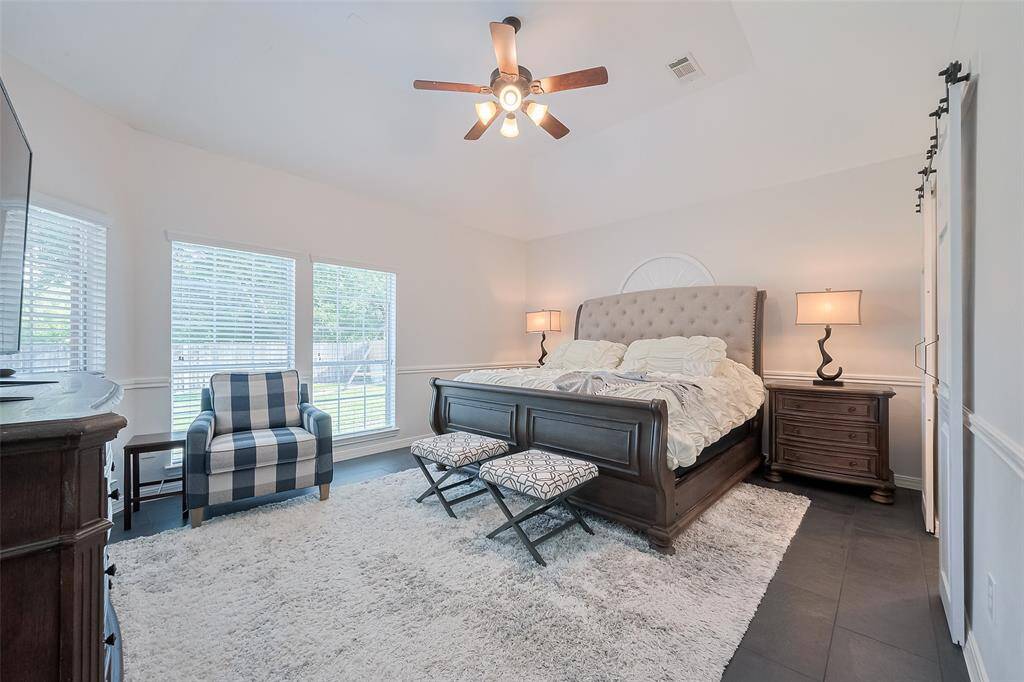Primary bedroom with more of that natural light and great view of the backyard.