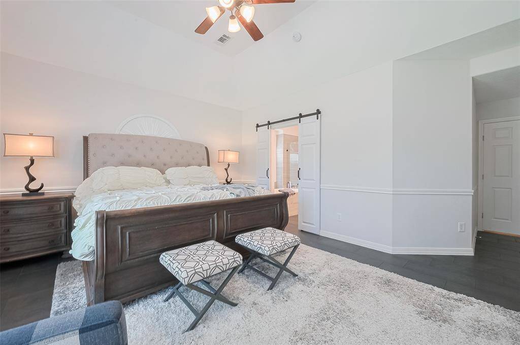 Primary bedroom has an ensuite bathroom, through double sliding barn doors.