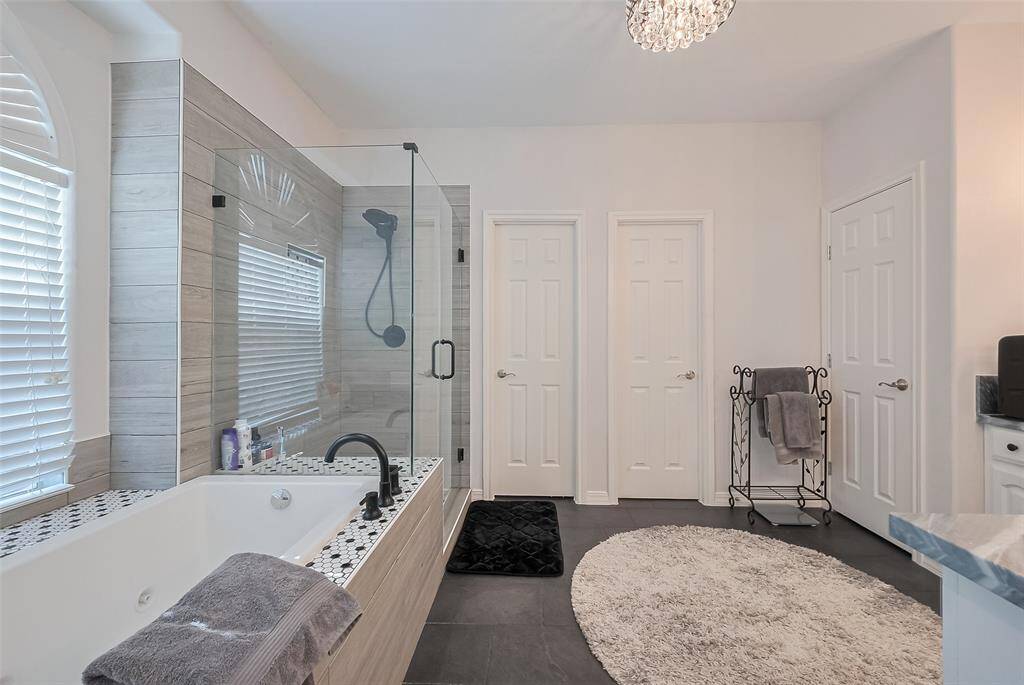 Tranquil ensuite bathroom with marble countertops, jetted tub, and separate shower.