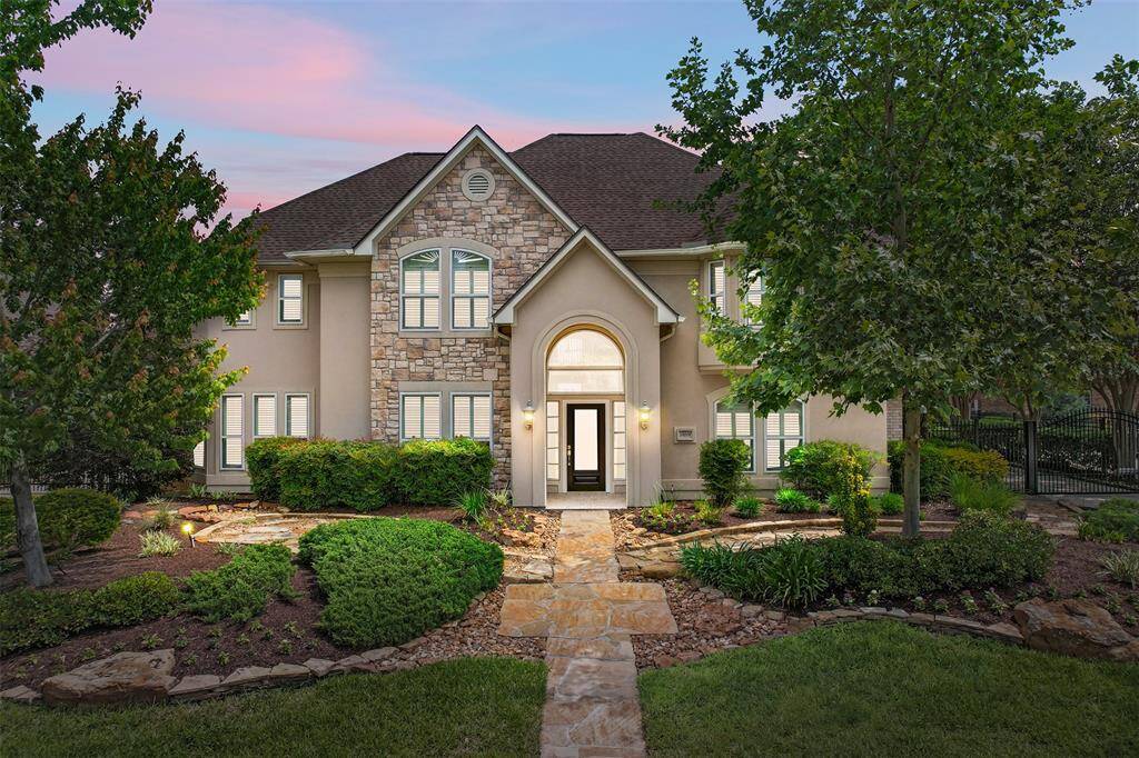 A striking first impression. This elegant two-story residence blends timeless stone and stucco finishes with lush, manicured landscaping. The gently lit entry path leads to a grand arched doorway—setting the tone for the style and sophistication found within.