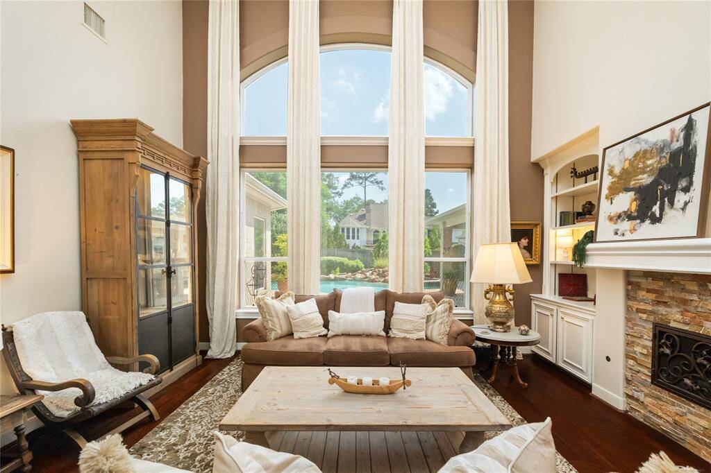 A space that invites you to linger. Sunlight pours through tall windows, drawing your eye to the serene backyard oasis just beyond. Inside, warm wood tones, custom built-ins, and a cozy fireplace create an atmosphere of effortless elegance—perfectly balancing comfort with refined living.