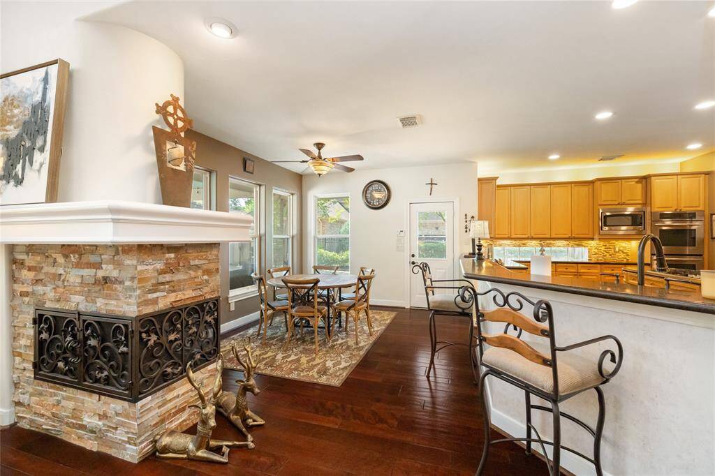 A space that radiates warmth and elegance. From the graceful spiral staircase to the inviting stone fireplace, this living room exudes luxury and comfort. Soaring ceilings and an open flow into the kitchen enhance the airy, spacious feel, making this the perfect place to unwind or entertain.