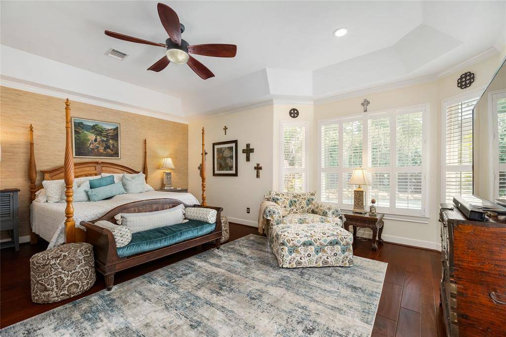 Your serene escape at the end of the day. This elegant primary bedroom offers rich wood flooring, abundant natural light through a large shuttered window, and a spacious, airy layout. The atmosphere is warm and refined—an ideal retreat designed for rest and relaxation.